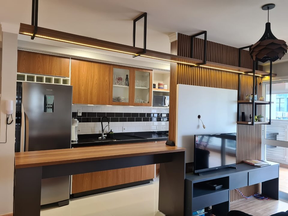 Cozinha em madeira e preto de um apartamento reformado pela Kratos